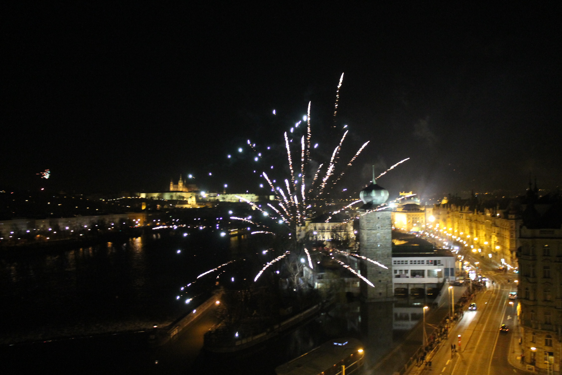 Prague : Le château illuminé et un feu d'artifice par dessus les toits